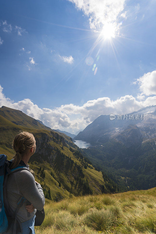 意大利北部Dolomites的Viel dal Pan小路上，一位老妇人正在欣赏美丽的Fedaia湖和Marmolada湖。